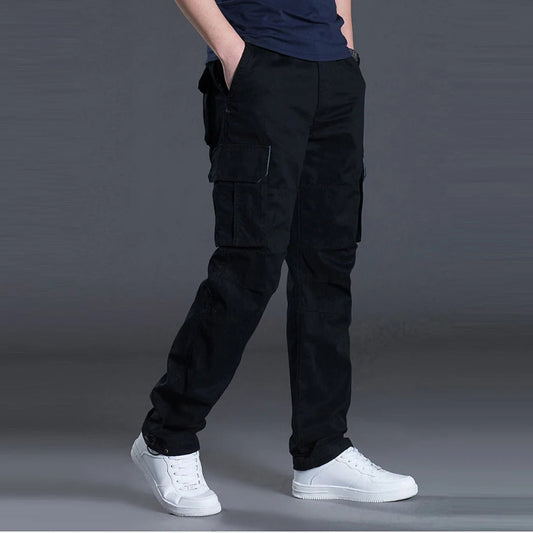 Person wearing black cargo pants and white sneakers on a gray background