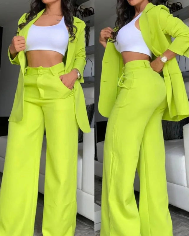 Woman wearing a bright green suit with a white top in an indoor setting.
