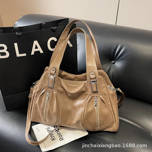 Brown handbag on a black surface with a 'BLACK' branded box in the background