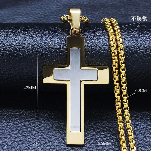Gold cross pendant and chain on a textured black surface