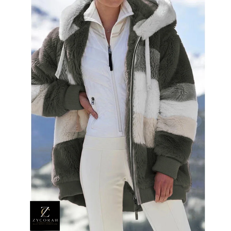 A person wearing a chunky striped teddy fleece jacket with a white zip-up top and white pants, photographed outdoors against a snowy mountain background. A ZYCOKAH logo appears in the bottom-left corner.