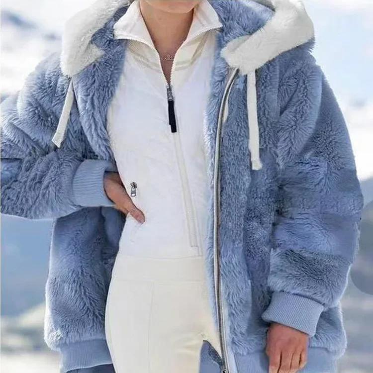 Person wearing a blue sherpa jacket with white interior against a blurred outdoor background