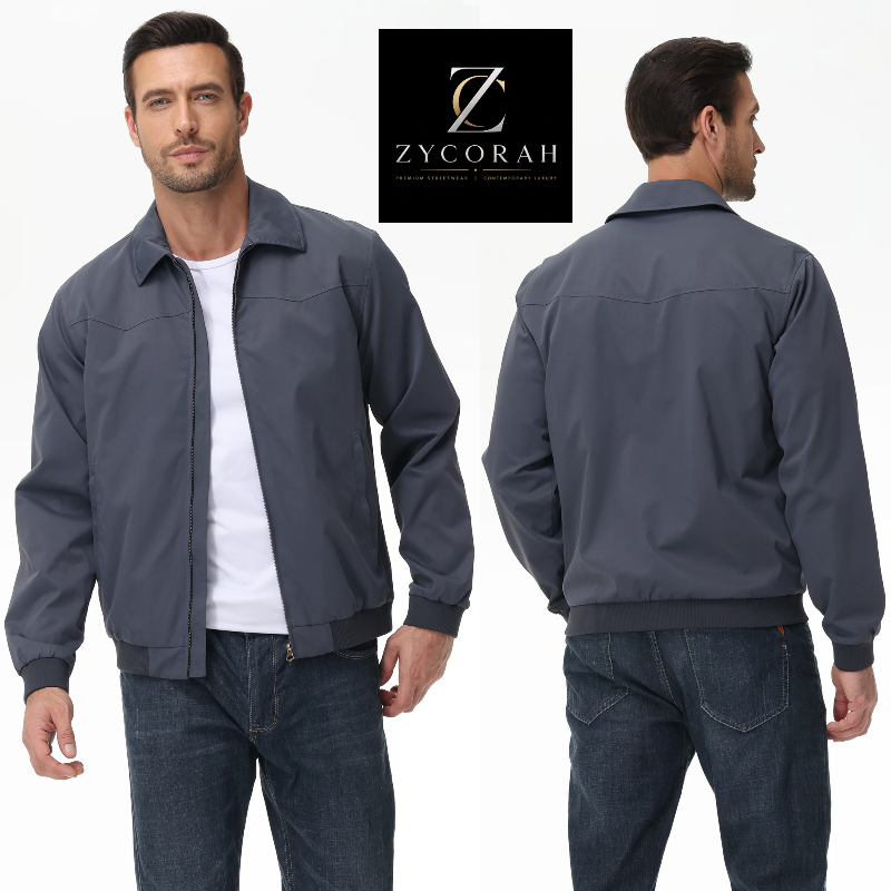 A man modeling a dark slate blue-gray zip-up bomber jacket, shown from both the front and back views against a clean white background. A black square logo for 'ZYCORAH' is displayed at the top center.