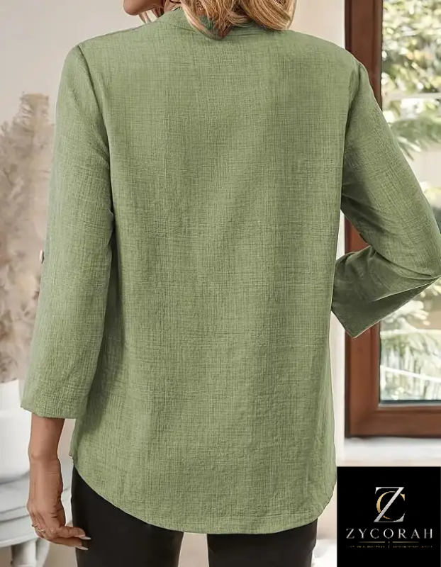 A woman wearing a sage green linen-blend long-sleeve top, shown from the back. The top has a relaxed fit and a high collar.