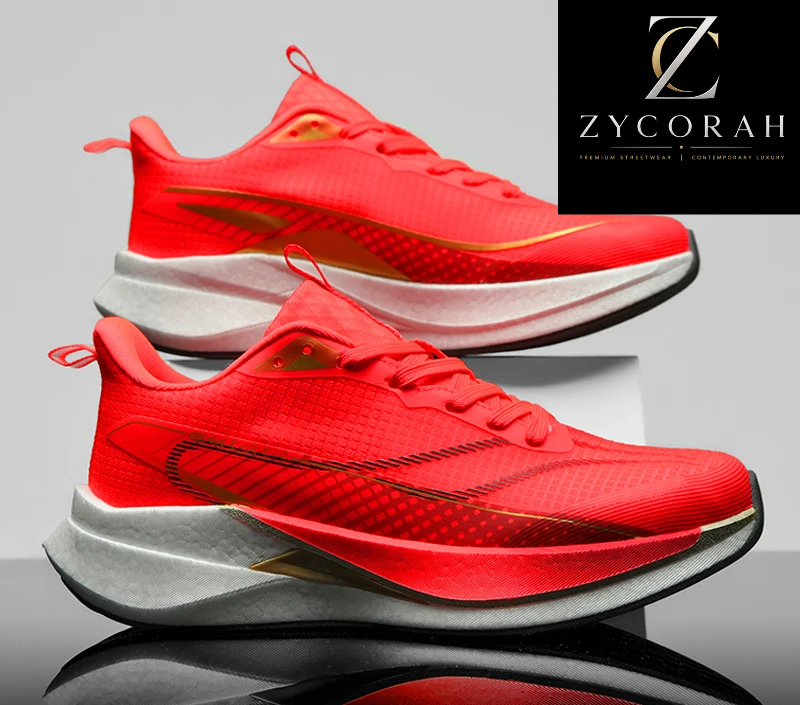 A pair of red athletic sneakers with white and gray midsoles, displayed on a reflective surface with a Zycorah brand logo in the top right corner and a promotional banner at the bottom.