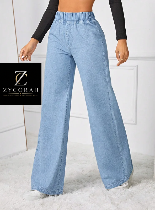 A model wears light blue wide-leg denim jeans with an elastic waistband, paired with a black long-sleeve top and white sneakers. A black square logo overlay for 'Zycorah' is positioned on the left side of the image.