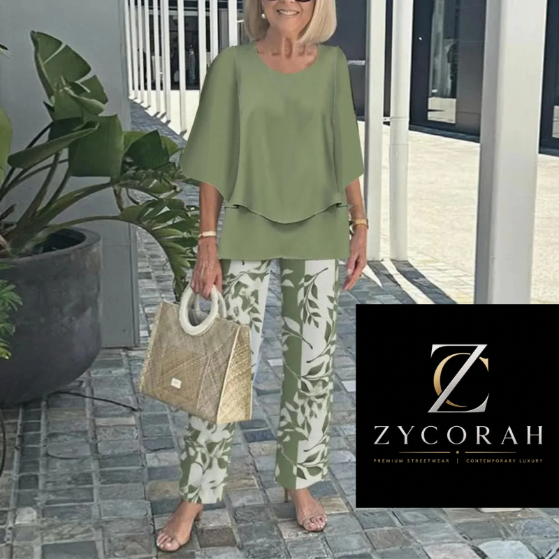 A woman models a two-piece lounge set consisting of an olive green short-sleeve top and matching green-and-white leaf-patterned pants, holding a woven straw bag. A black brand overlay for 'Zycorah' is visible in the bottom right corner.
