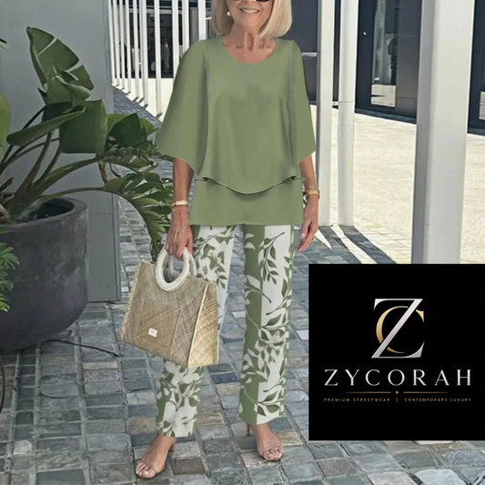 A woman models a two-piece lounge set consisting of an olive green short-sleeve top and matching green-and-white leaf-patterned pants, holding a woven straw bag. A black brand overlay for 'Zycorah' is visible in the bottom right corner.