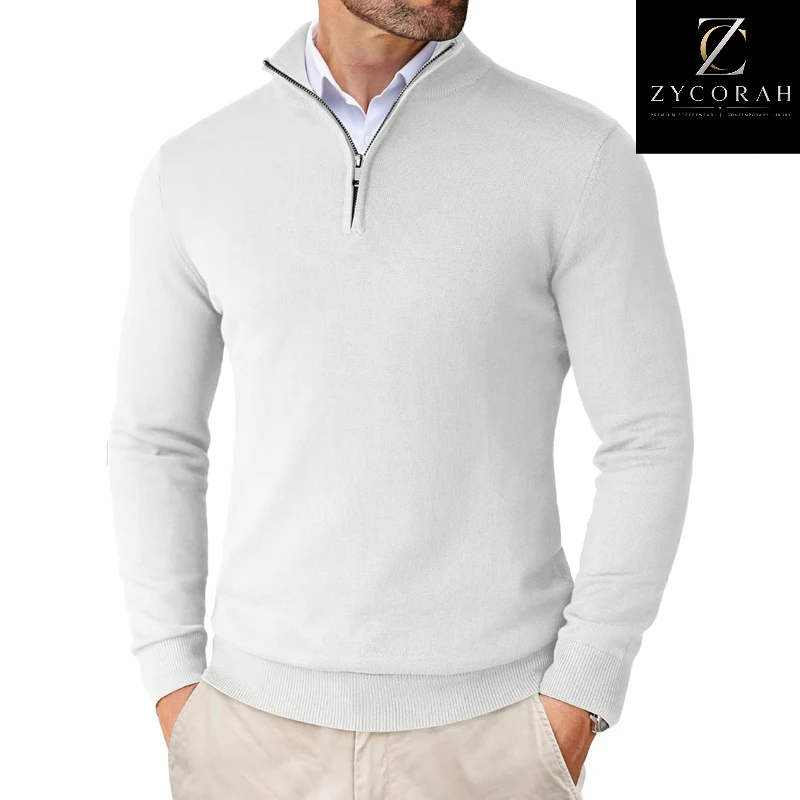 A man wearing a light gray quarter-zip knit sweater over a light blue collared shirt, paired with beige trousers. A black brand logo for ZYCORAH is visible in the top right corner.