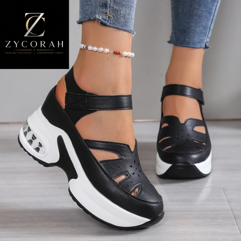 A pair of women's black platform cutout sandals with white soles, shown on a model's feet. The model is wearing blue jeans and a pearl anklet.