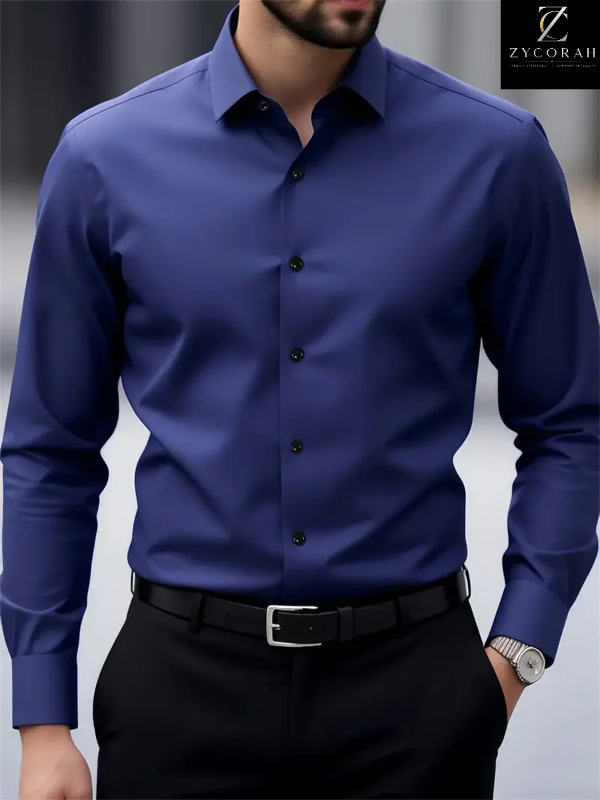 A man wearing a royal blue long-sleeve button-down dress shirt tucked into black trousers with a black belt. The image is cropped from the chin down, showing the fit of the shirt.