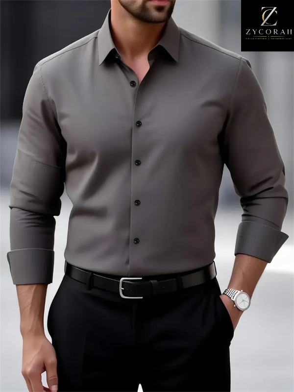 A man wearing a fitted long-sleeve button-up dress shirt in dark gray, paired with black trousers and a black belt. The ZYCORAH brand logo is visible in the top right corner.