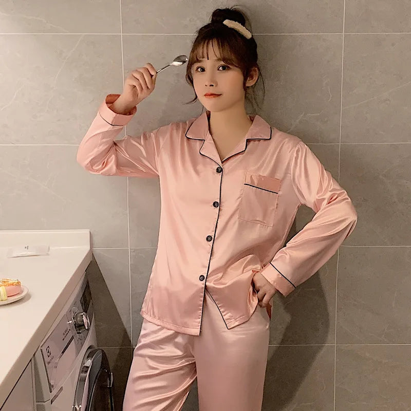 Person wearing pink satin pajamas holding a spoon in a kitchen.