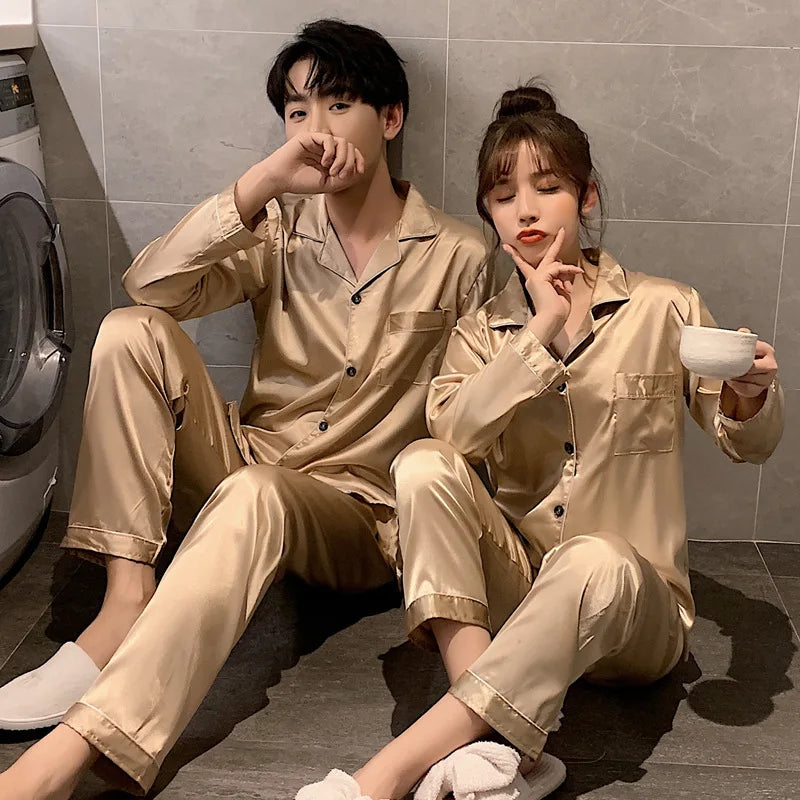 Two people wearing matching beige pajama sets sitting on the floor.