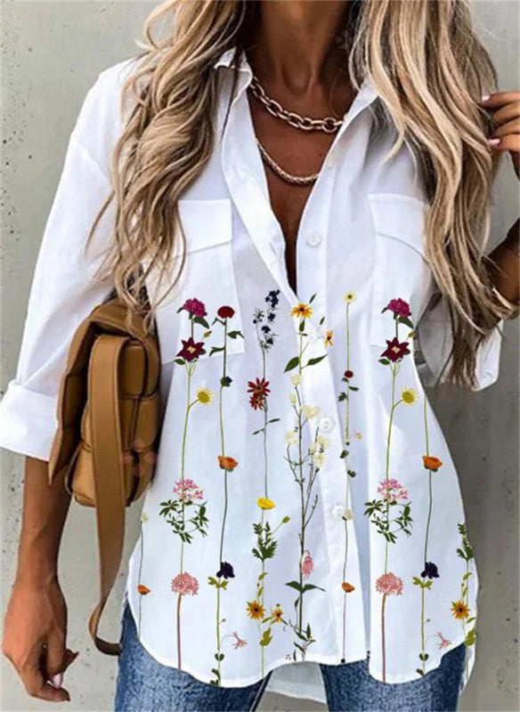 Woman wearing a white shirt with floral patterns, holding a tan backpack.