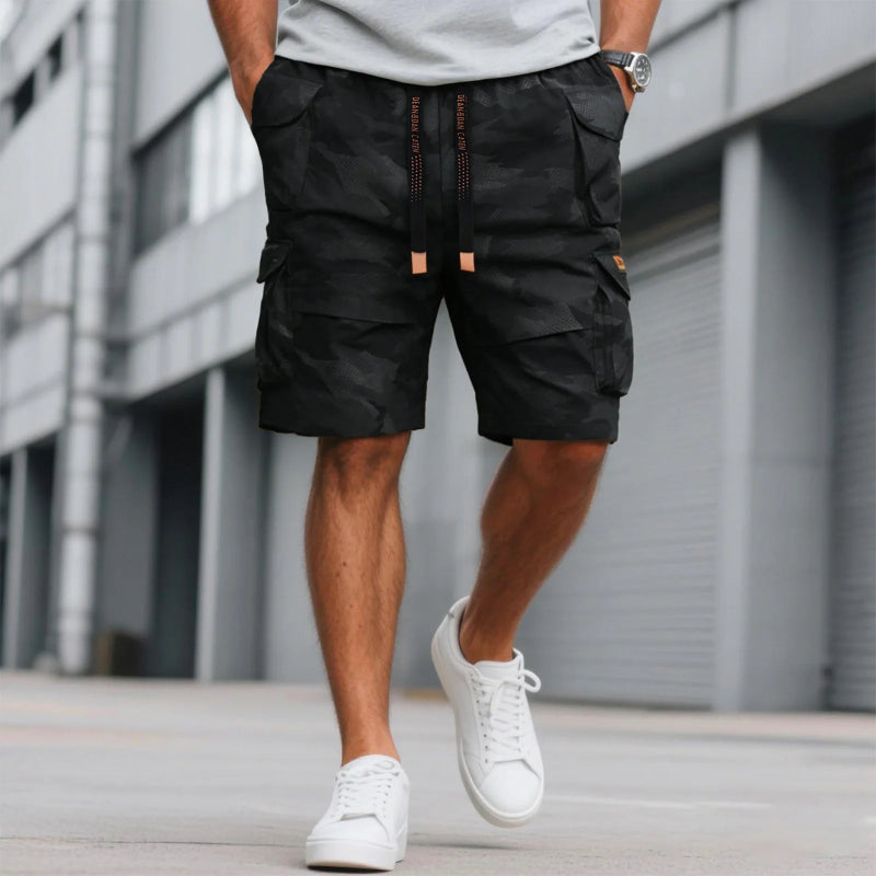 Person wearing black cargo shorts and white sneakers in an urban setting