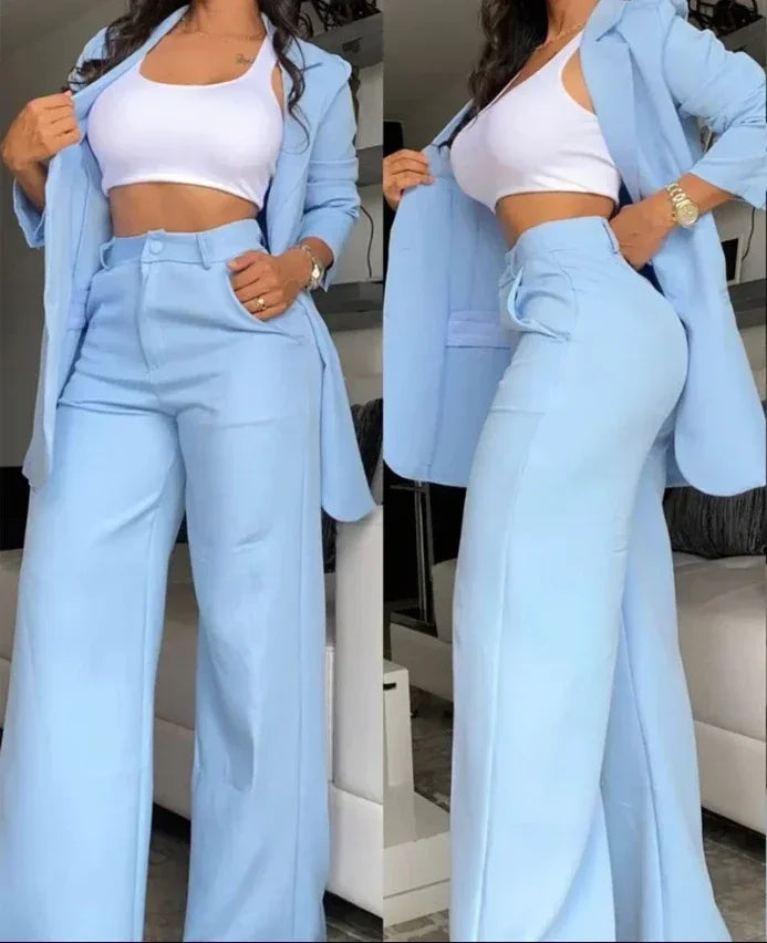 Woman wearing a light blue suit with a white top in an indoor setting.