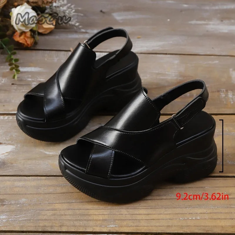Black sandals on a wooden surface with measurement label