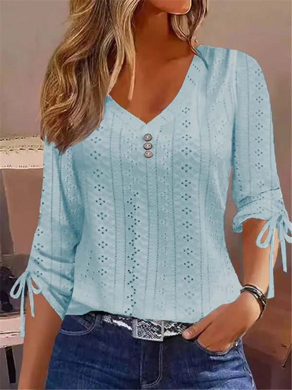 Light blue blouse with eyelet details and tied sleeves worn by a person.