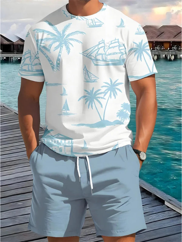 Person wearing a white t-shirt with blue palm tree and boat pattern and light blue shorts by a waterfront.