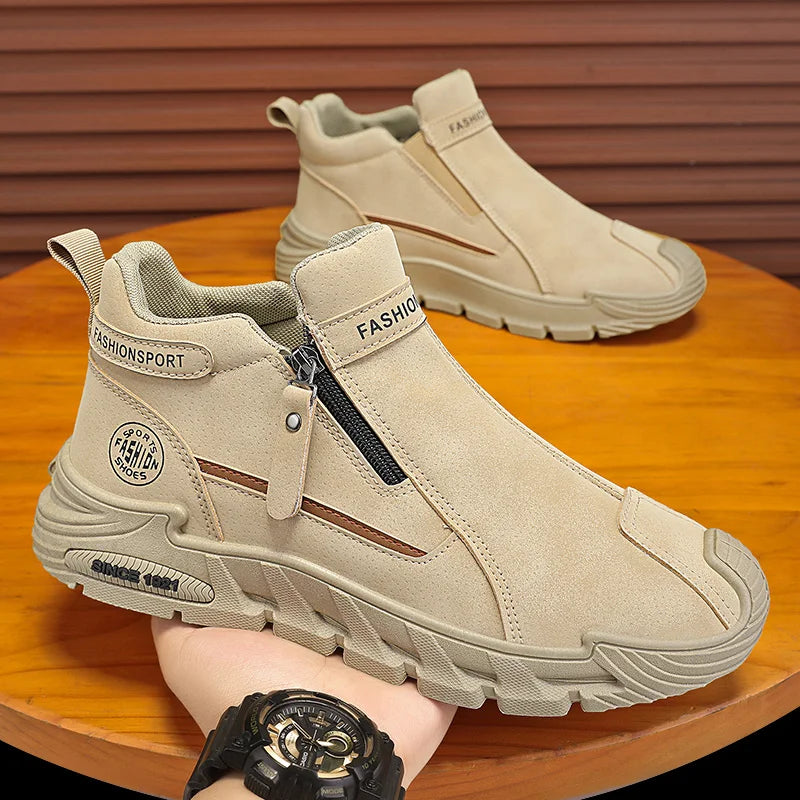 Beige ankle boots with zippers on a wooden surface, worn by a person.