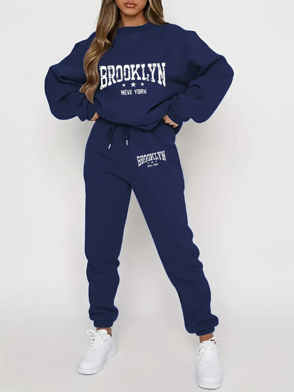Navy blue 'Brooklyn New York' sweatshirt and jogger set with white sneakers on a white background