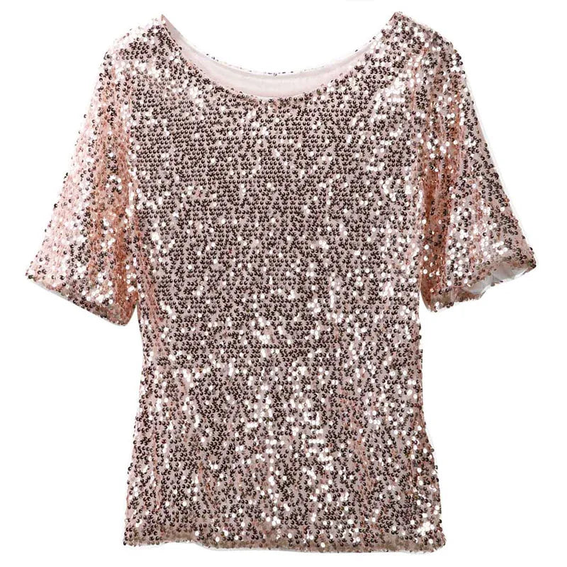 Woman wearing sloping shoulder sequin T-shirt in a casual streetwear setting with soft lighting
