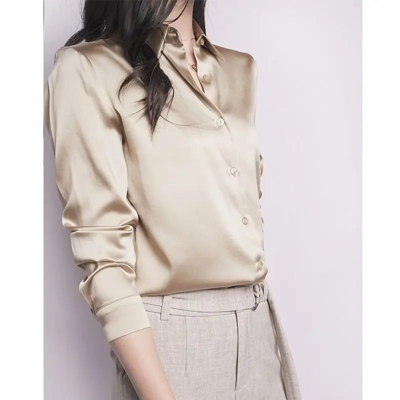 Beige satin shirt worn by a person on a plain background
