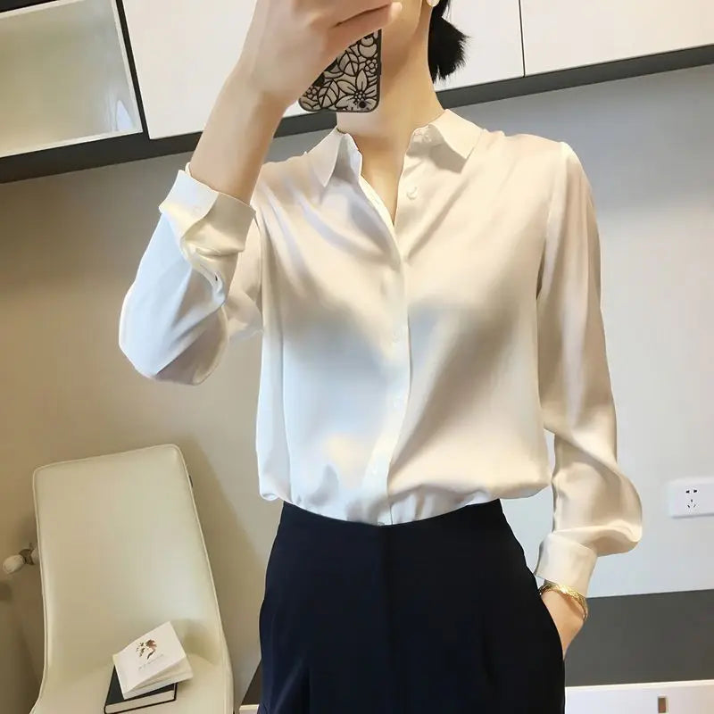 Person wearing a white blouse with long sleeves in an indoor setting