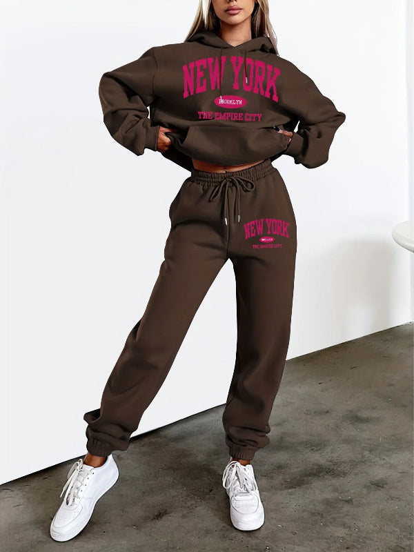 Brown 'New York' tracksuit worn by a person on a white background