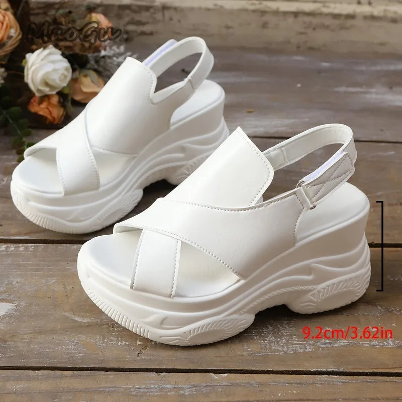 White sandals with thick soles on a wooden surface