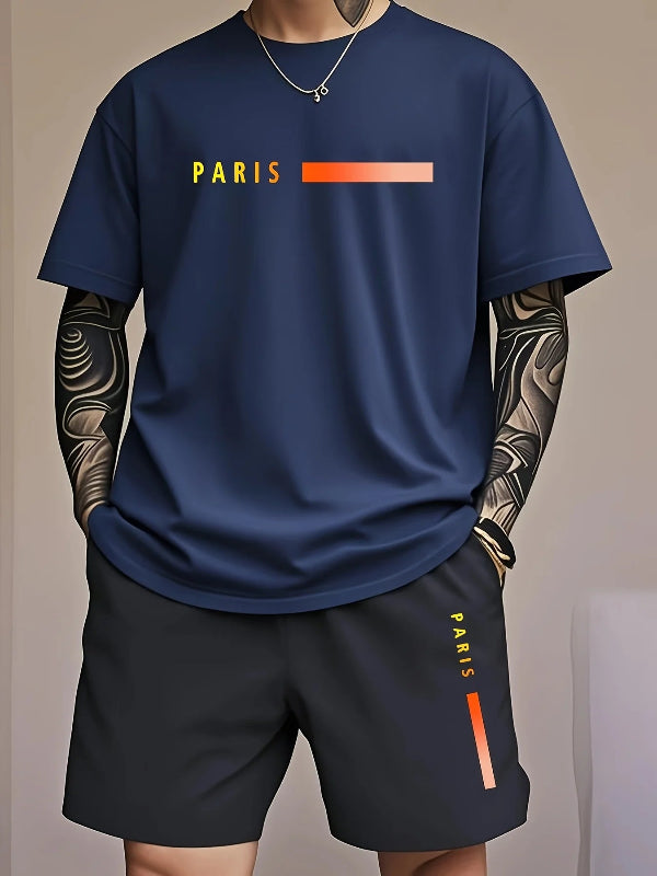 Person wearing a navy blue t-shirt and black shorts with 'PARIS' branding on a neutral background