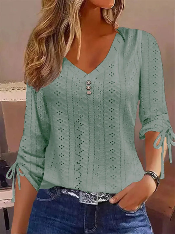 Green lace-up blouse worn by a person with a neutral background