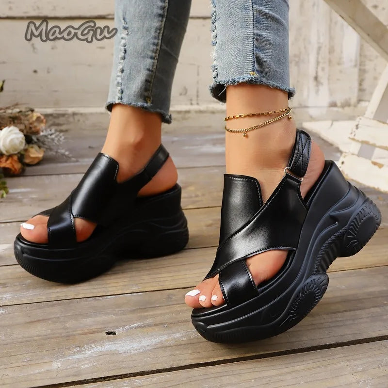 Black platform sandals worn on a wooden floor with 'MaoGu' branding.
