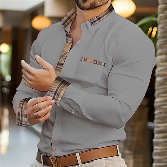 Man wearing a gray shirt with plaid accents in an indoor setting