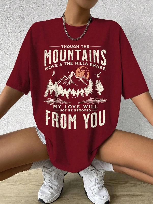 Person wearing a red t-shirt with a motivational quote and mountain graphic.