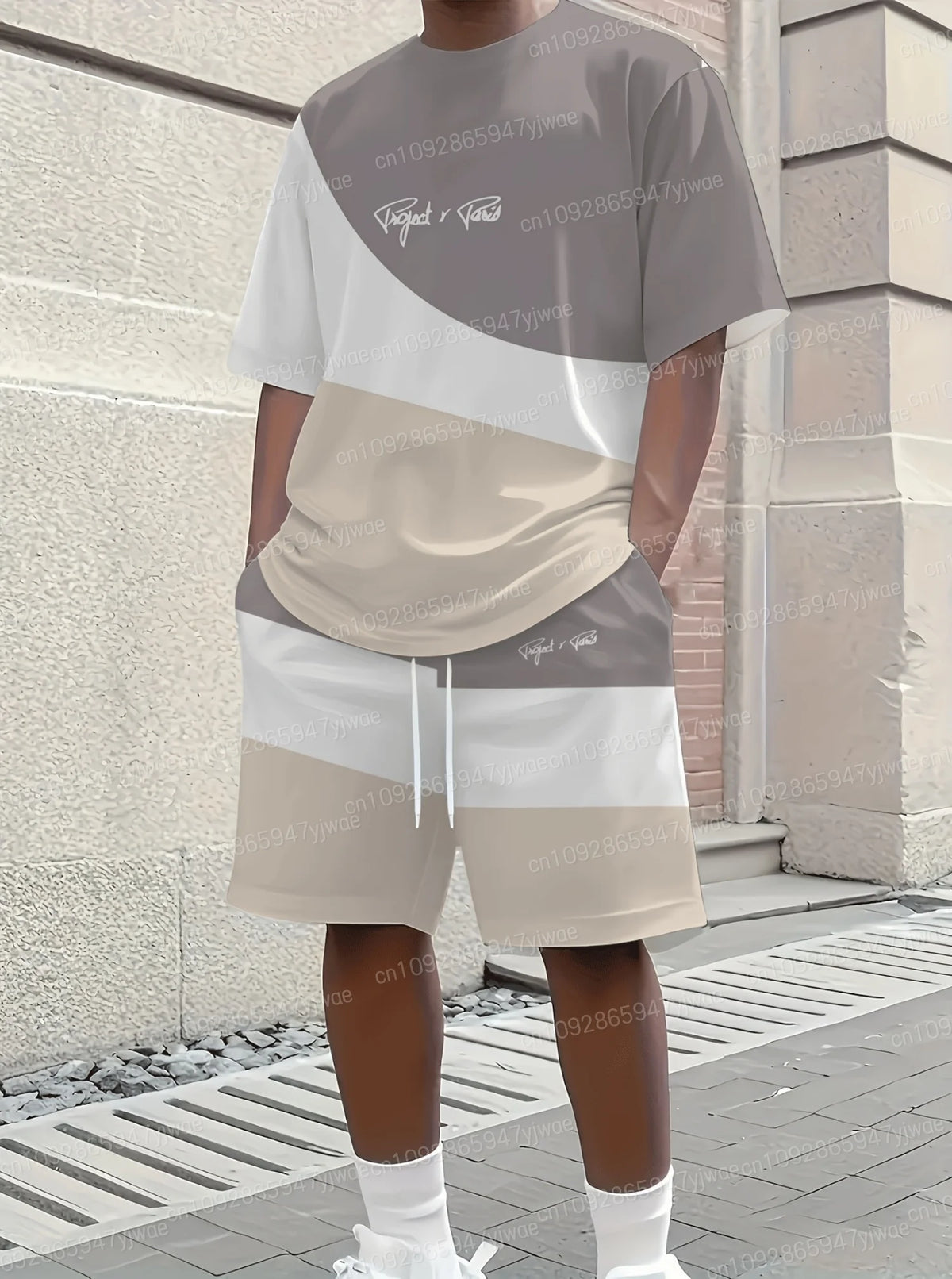 Person wearing a gray and beige outfit with text on a building background