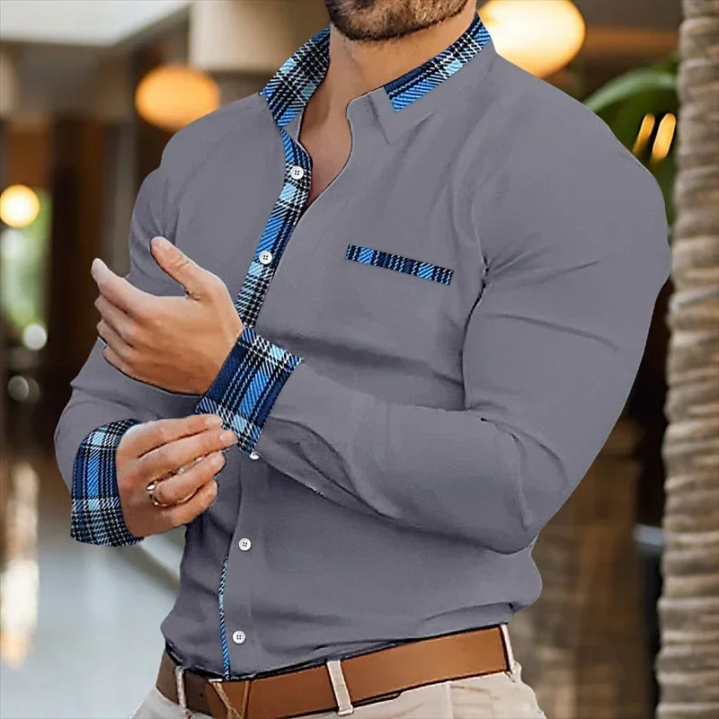 Man wearing a gray shirt with blue plaid accents in an indoor setting