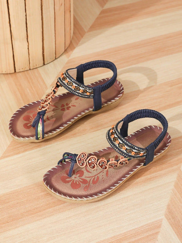 Pair of sandals with floral design on a wooden floor
