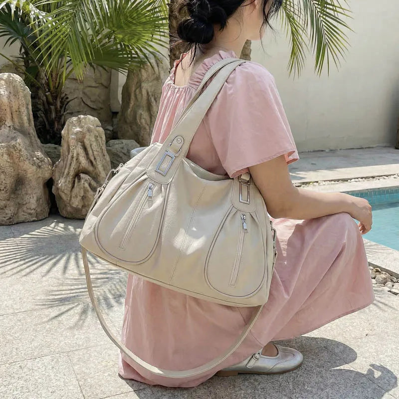 Woman in a pink dress holding a beige handbag by a poolside with plants in the background