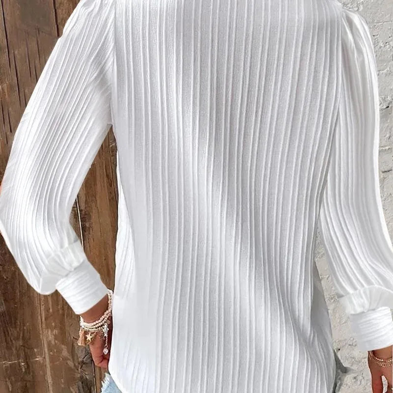 White pleated shirt worn by a person with a neutral background