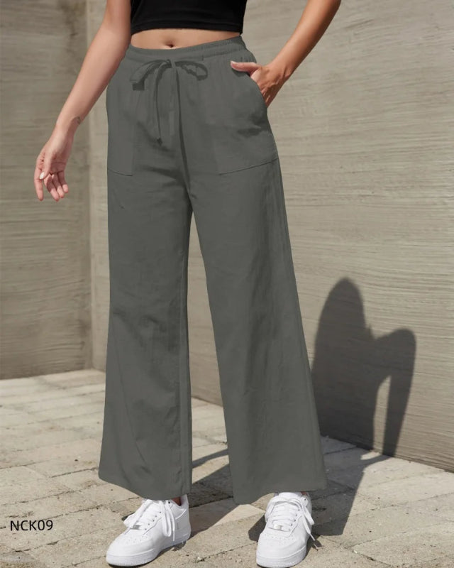 Person wearing gray wide-leg pants with a plain background
