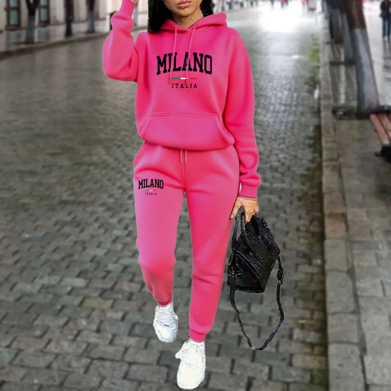 Person wearing a pink 'Milano Italia' tracksuit on a city street.