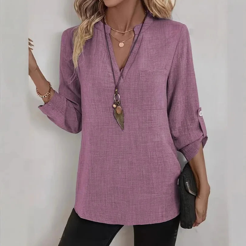 Woman wearing a purple long-sleeve shirt with a plain background