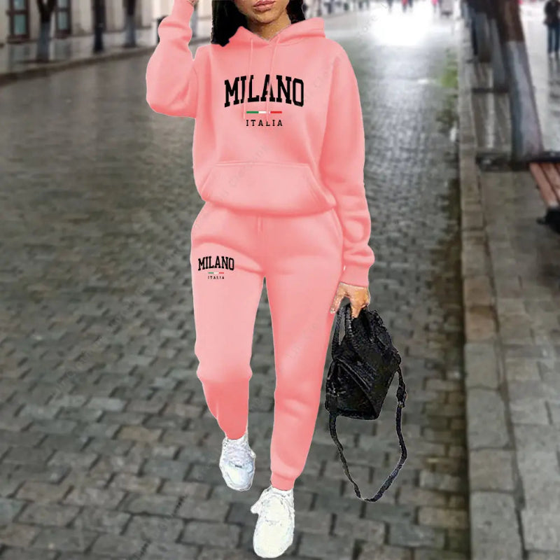 Person wearing a pink 'Milano Italia' tracksuit on a city street.