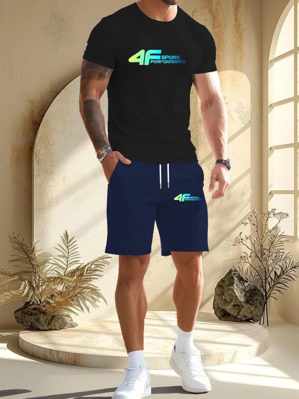 Person wearing a black t-shirt and blue shorts with a brand logo, standing in a sunlit room.