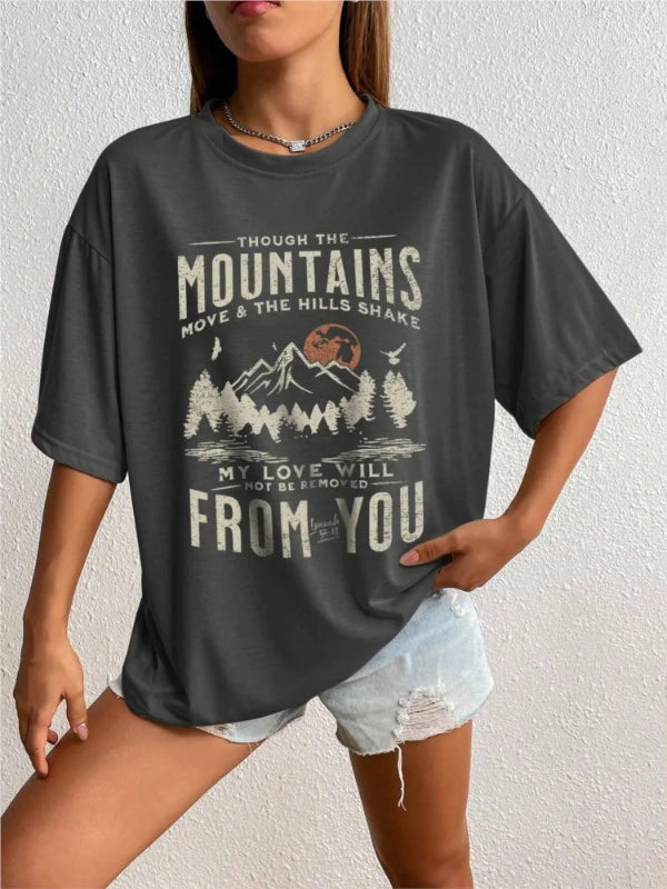 Person wearing a dark gray t-shirt with a mountain graphic and text.