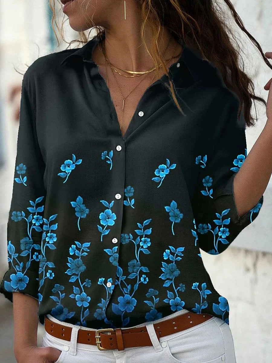 Black blouse with blue floral patterns worn by a person.