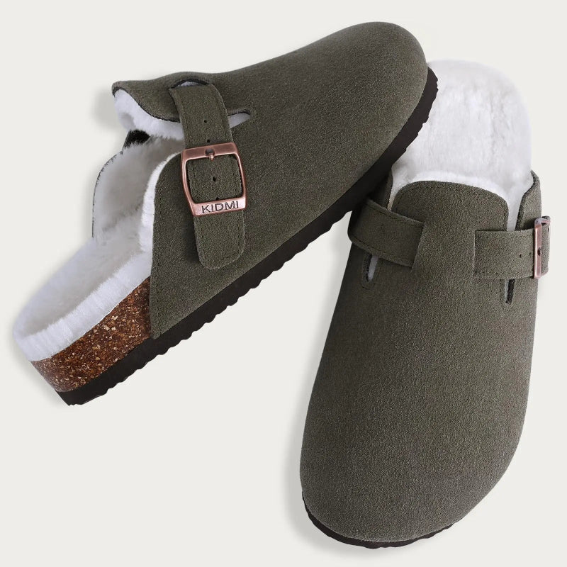 Pair of green slippers with white lining and brown buckle on a light gray background