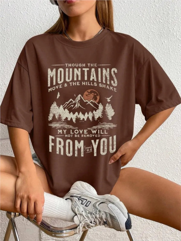 Person wearing a brown t-shirt with mountain graphic and text